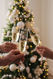 Photo of People clinking glasses with champagne at home, closeup