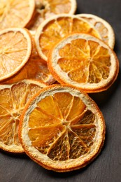 Photo of Dry orange slices on black table, closeup