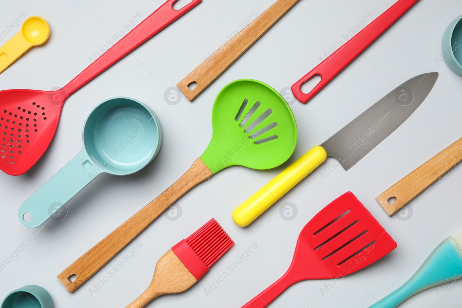 Photo of Set of modern cooking utensils on light background, flat lay