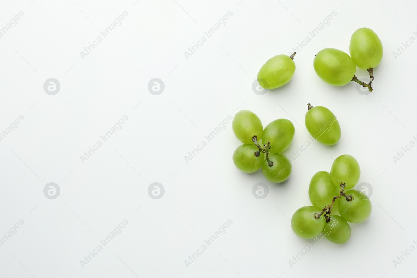 Photo of Fresh grapes on white background, top view. Space for text