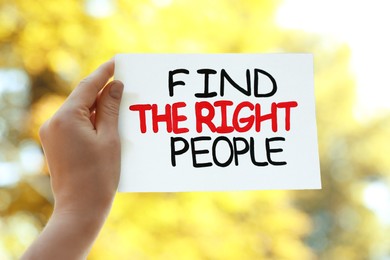 Photo of Woman holding card with phrase Find The Right People against blurred background, closeup