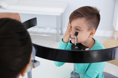 Children's doctor examining little boy's vision in clinic
