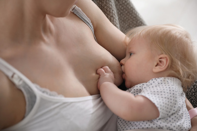 Photo of Mother breastfeeding her cute little baby, closeup