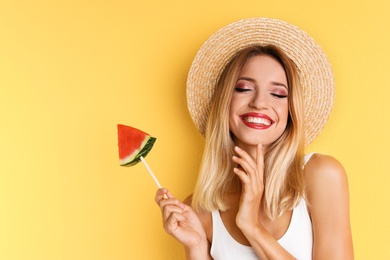 Pretty young woman with juicy watermelon on color background