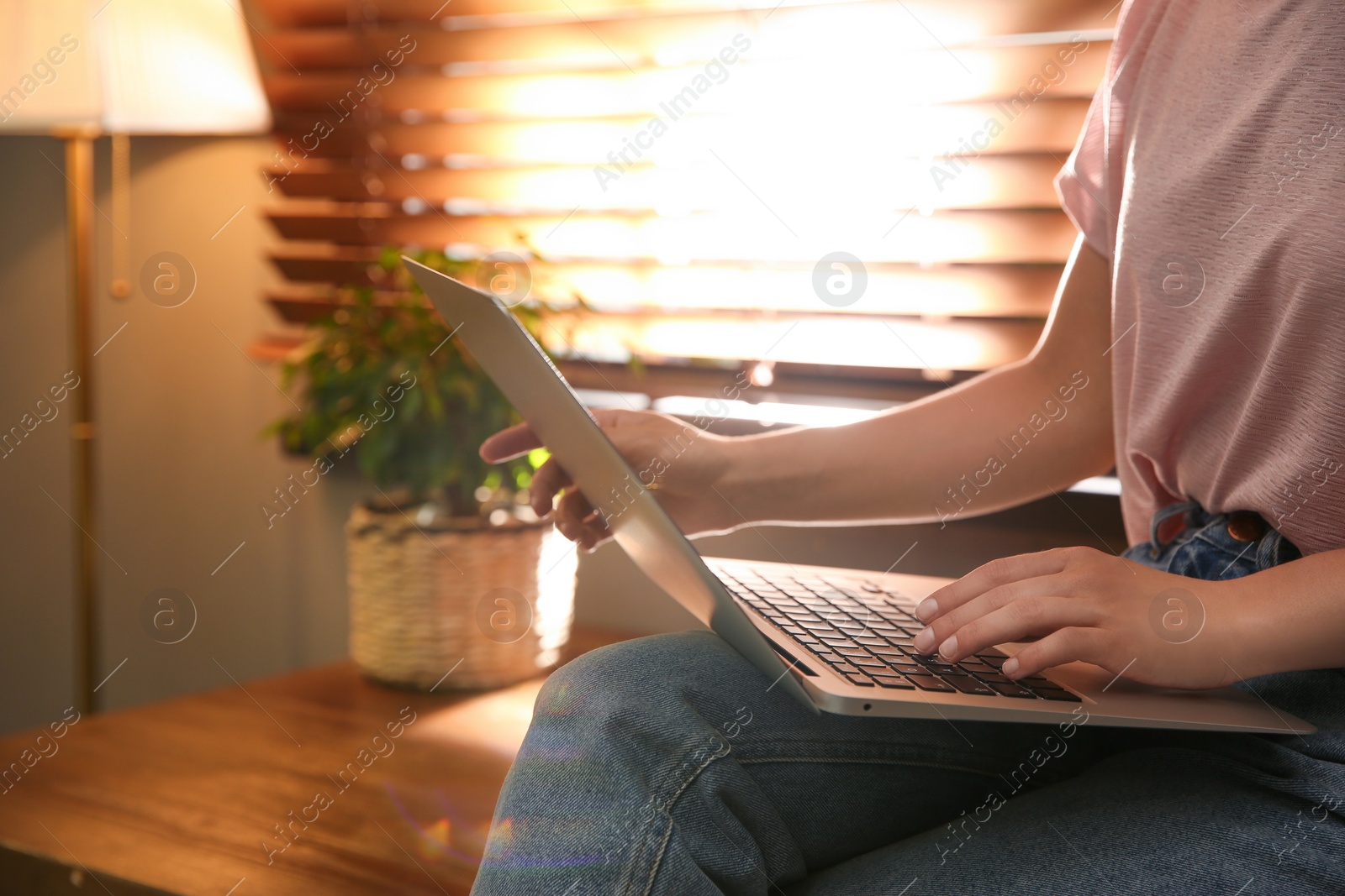 Photo of Woman working with modern laptop indoors, closeup