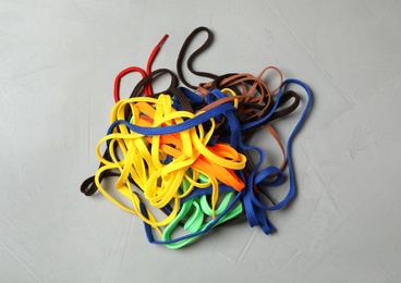 Photo of Pile of shoelaces on light grey stone background, flat lay