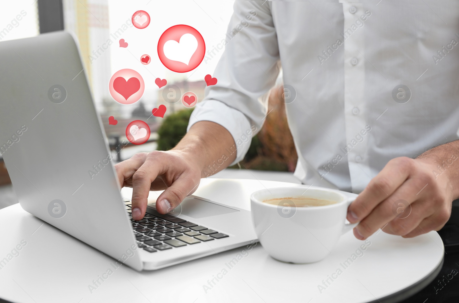 Image of Young man with coffee using laptop in outdoor cafe, closeup. Social media