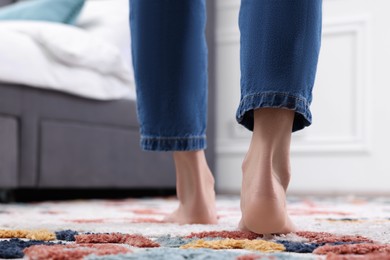 Woman walking on carpet with pattern at home, closeup