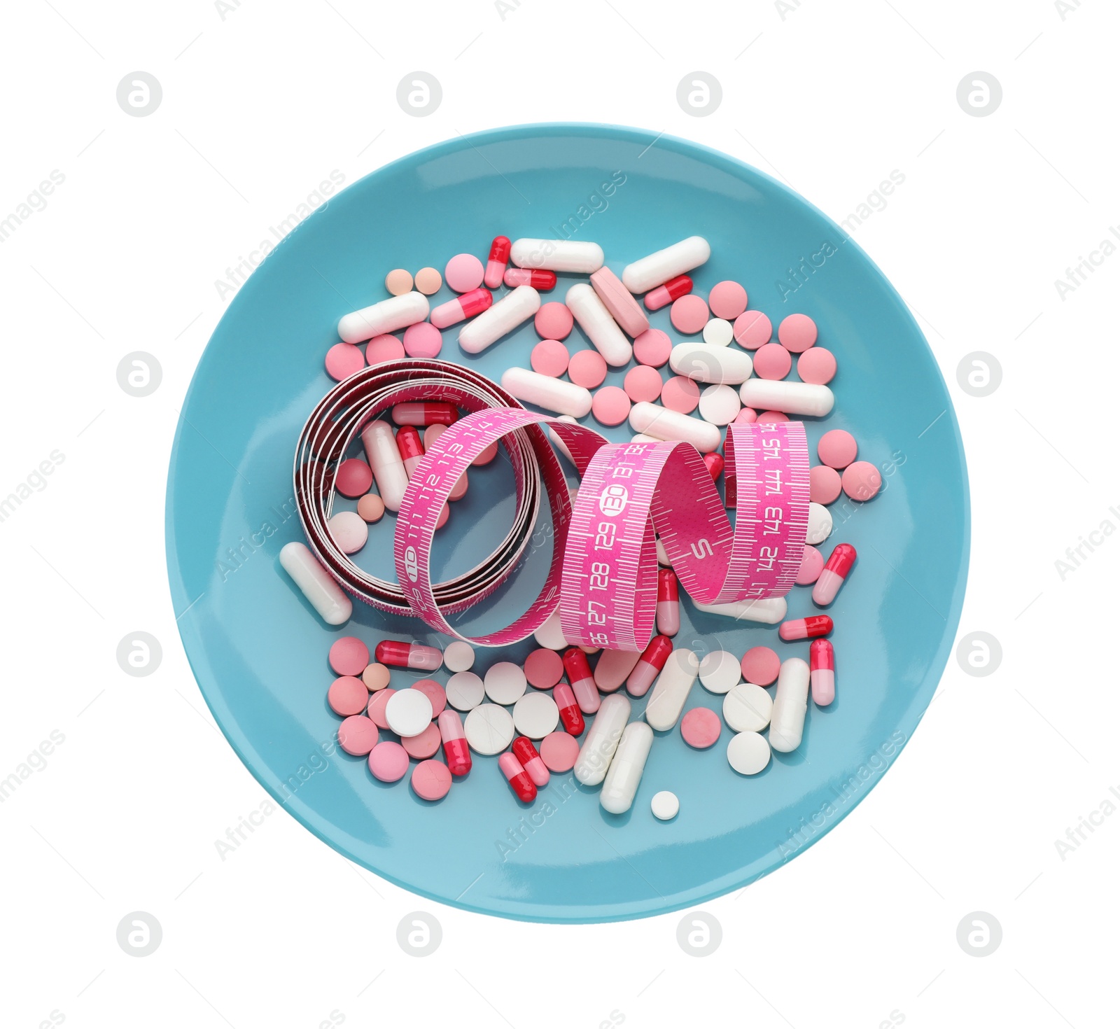 Photo of Plate with weight loss pills and measuring tape on white background, top view