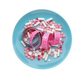 Photo of Plate with weight loss pills and measuring tape on white background, top view