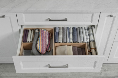 Open drawer with different textiles in kitchen