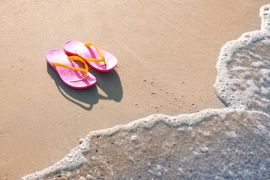 Photo of Stylish flip flops on beach. Space for text