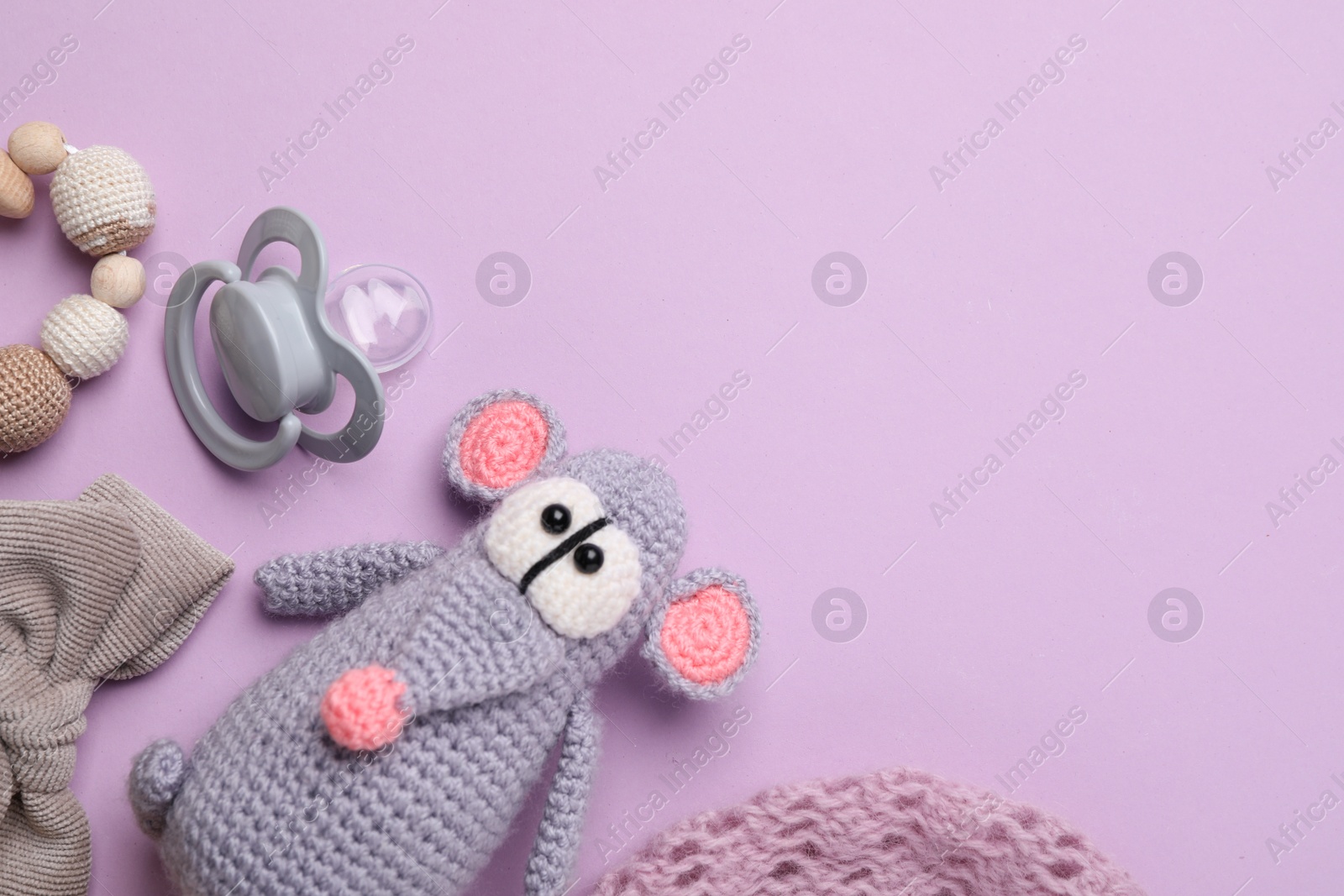 Photo of Flat lay composition with pacifier and other baby stuff on violet background. Space for text