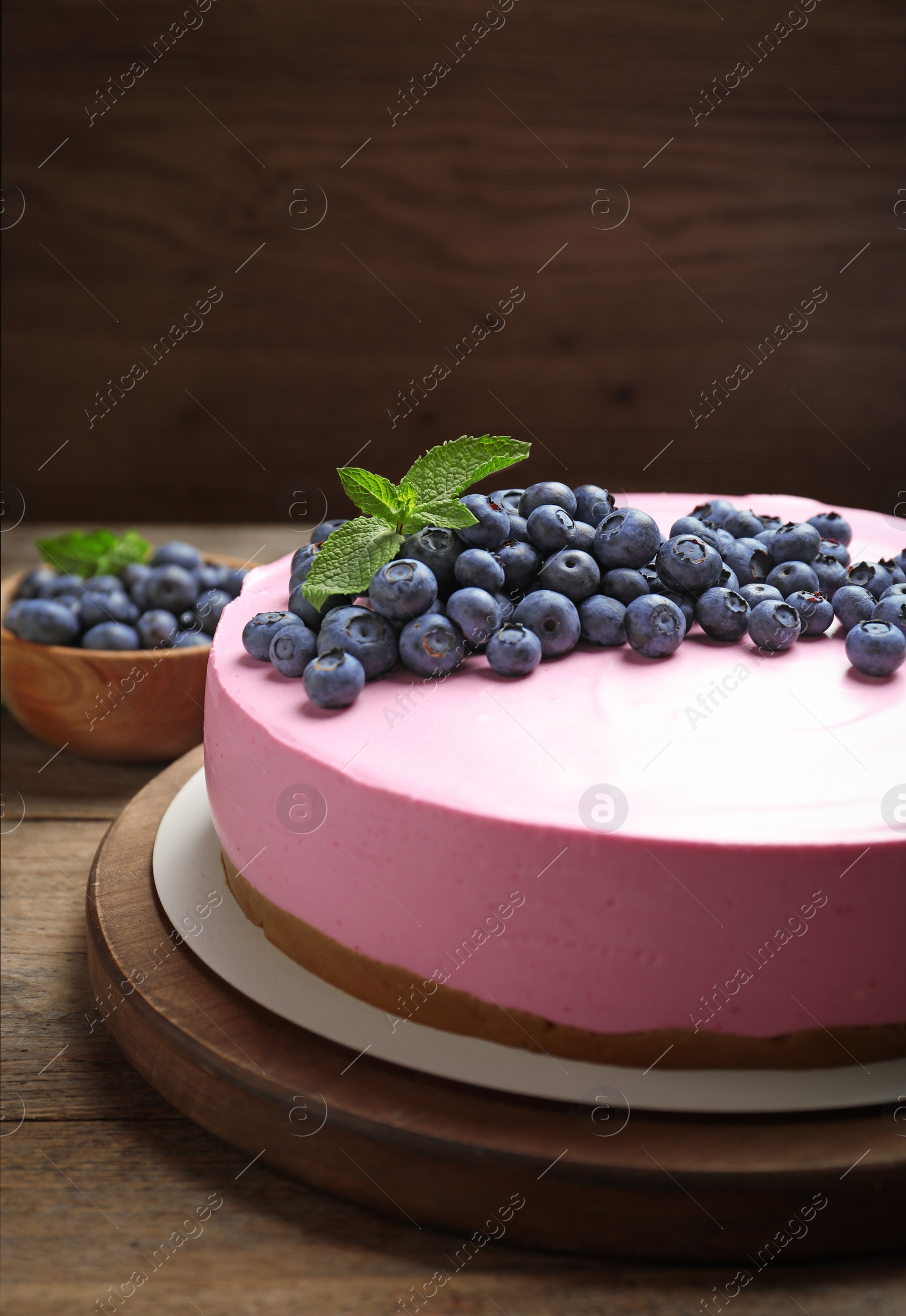 Photo of Board with tasty blueberry cake on wooden table. Space for text