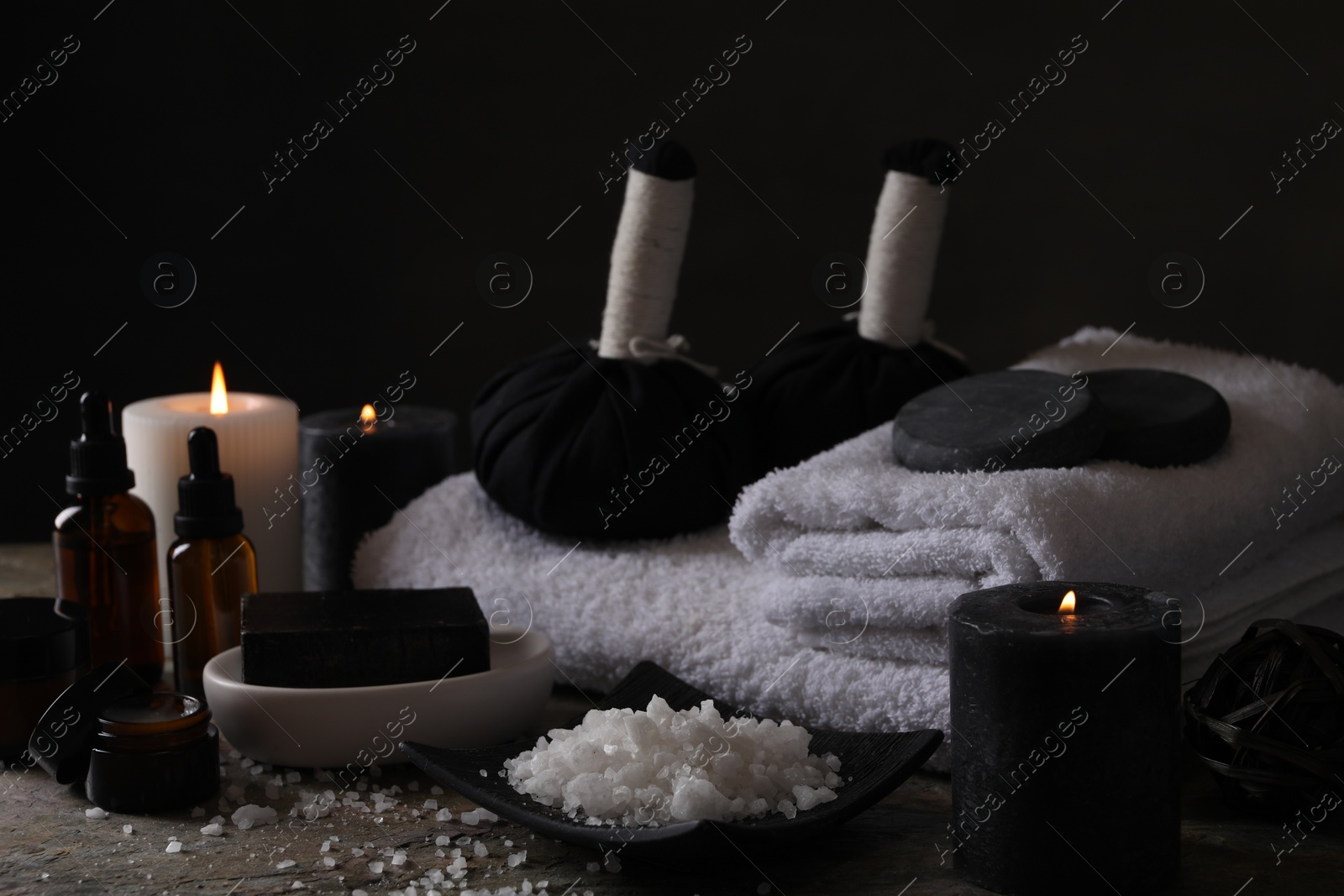 Photo of Composition with different spa products and burning candles on grey textured table