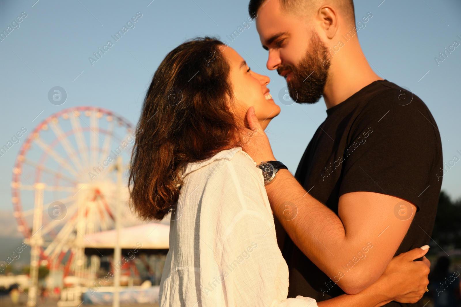 Photo of Happy young couple kissing in amusement park