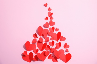 Small paper hearts on color background, top view