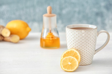 Photo of Cup of tea and lemon on table. Space for text