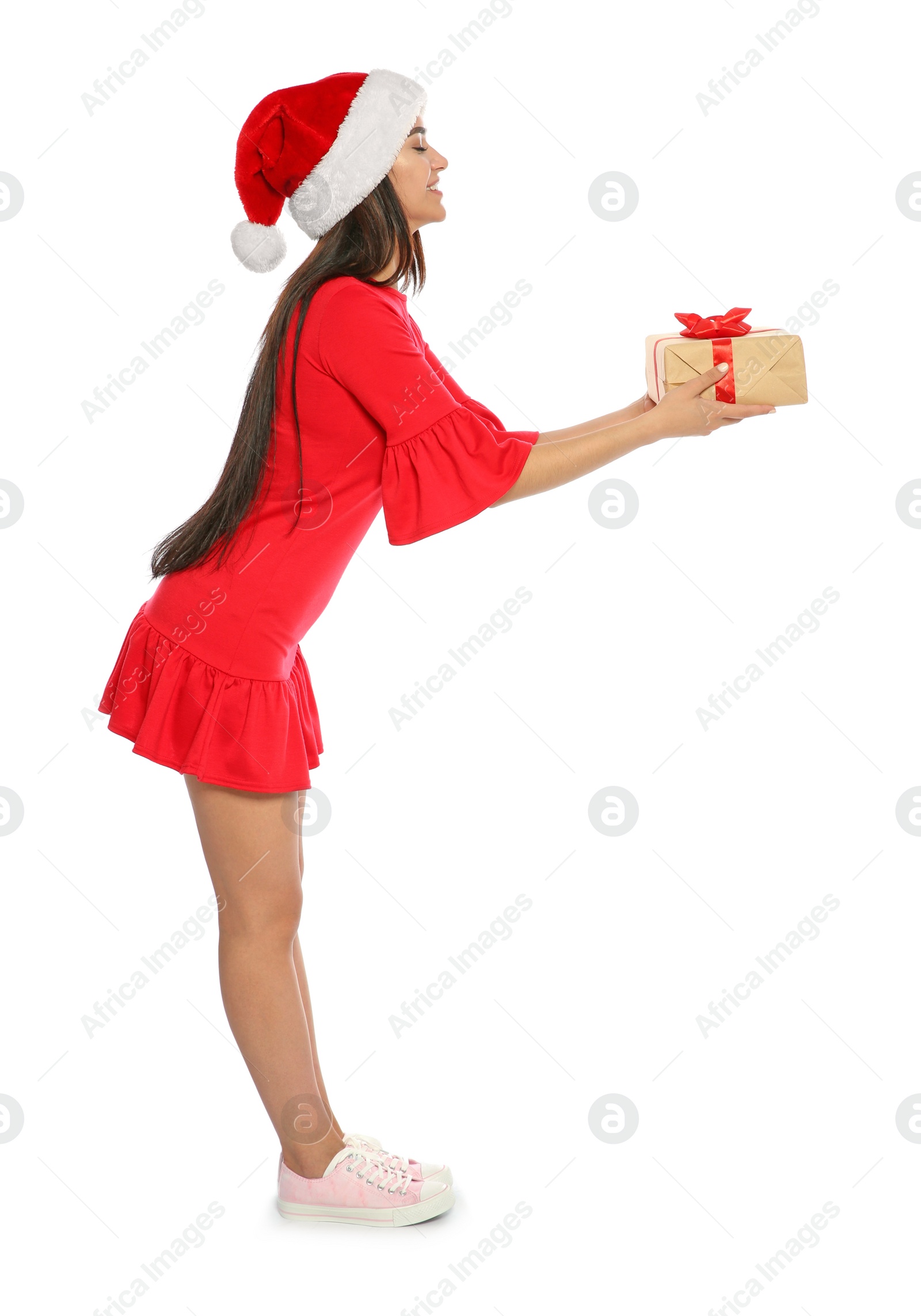 Photo of Young happy woman with Santa hat and gift box on white background. Christmas celebration