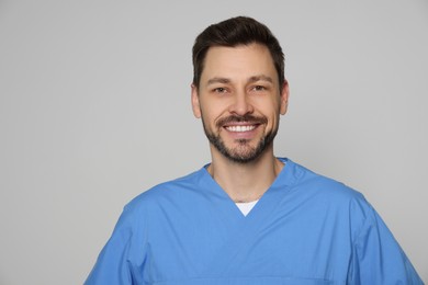 Doctor or medical assistant (male nurse) in uniform on light grey background