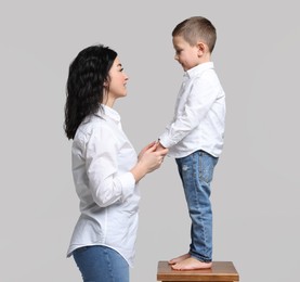 Photo of Beautiful mother with little son on white background