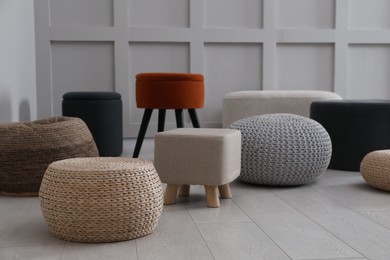 Different stylish poufs and ottomans in room