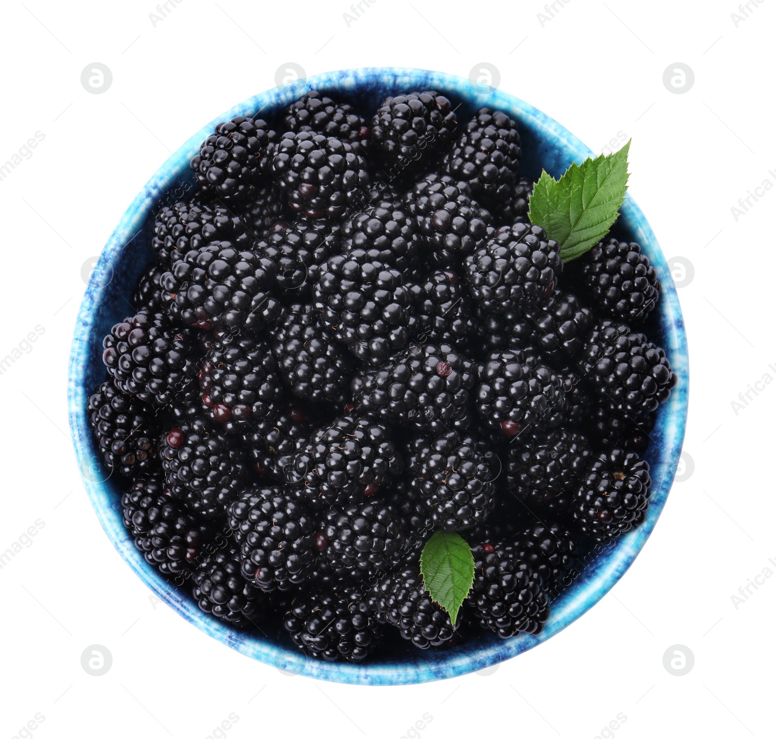 Photo of Blue bowl of tasty ripe blackberries with leaves on white background, top view