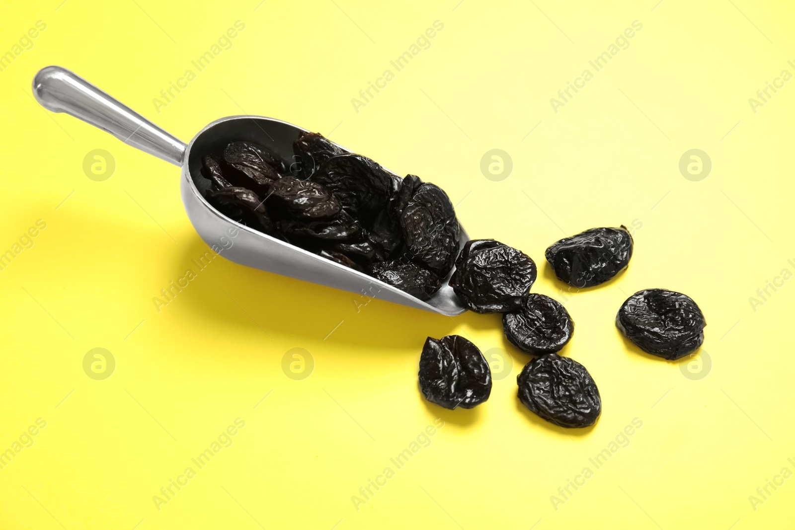 Photo of Scoop of dried plums on color background. Healthy fruit
