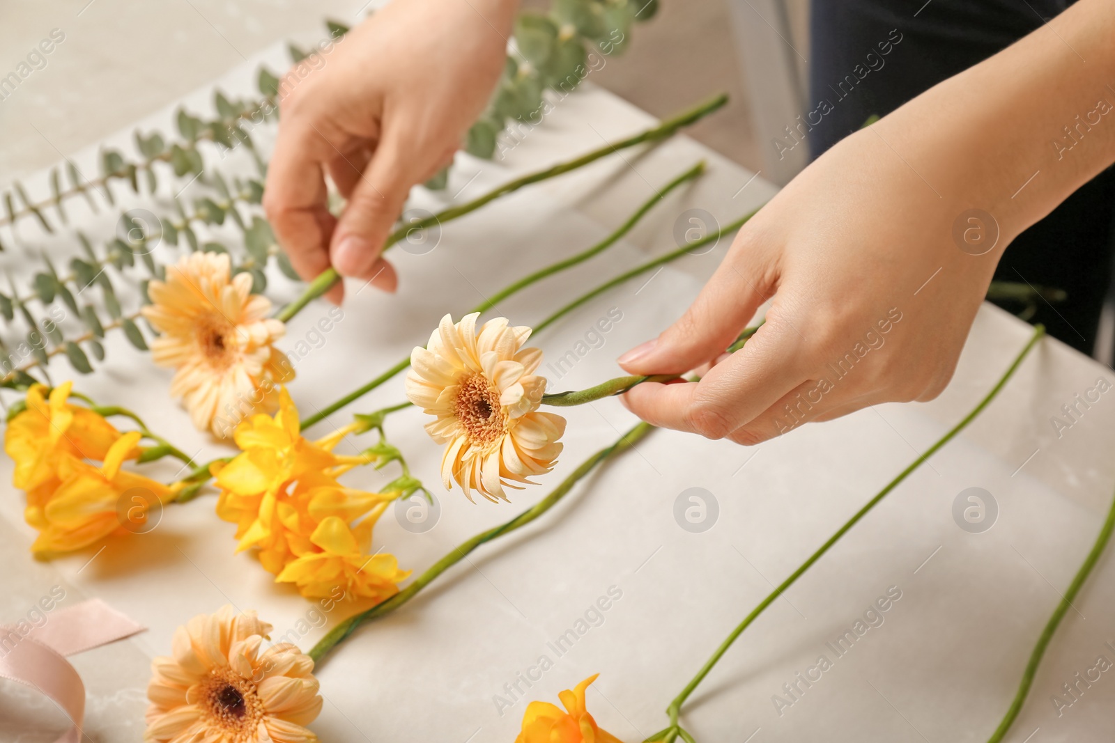 Photo of Female florist making beautiful bouquet at table