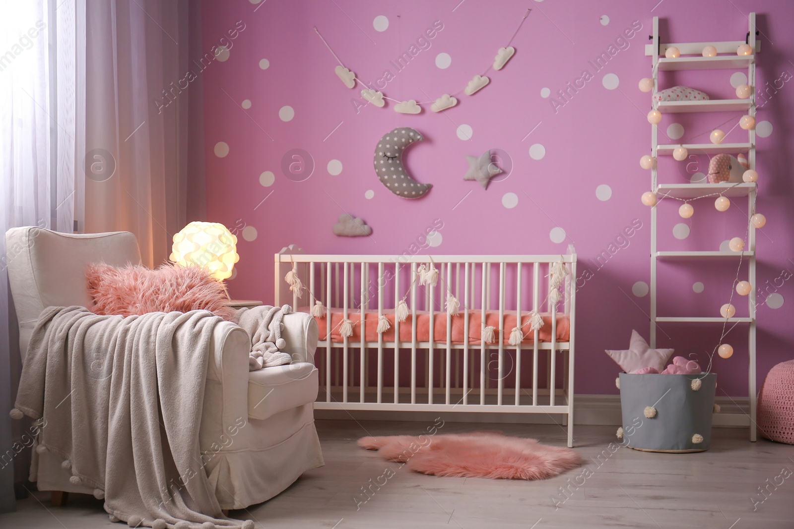 Photo of Baby room interior with crib near color wall