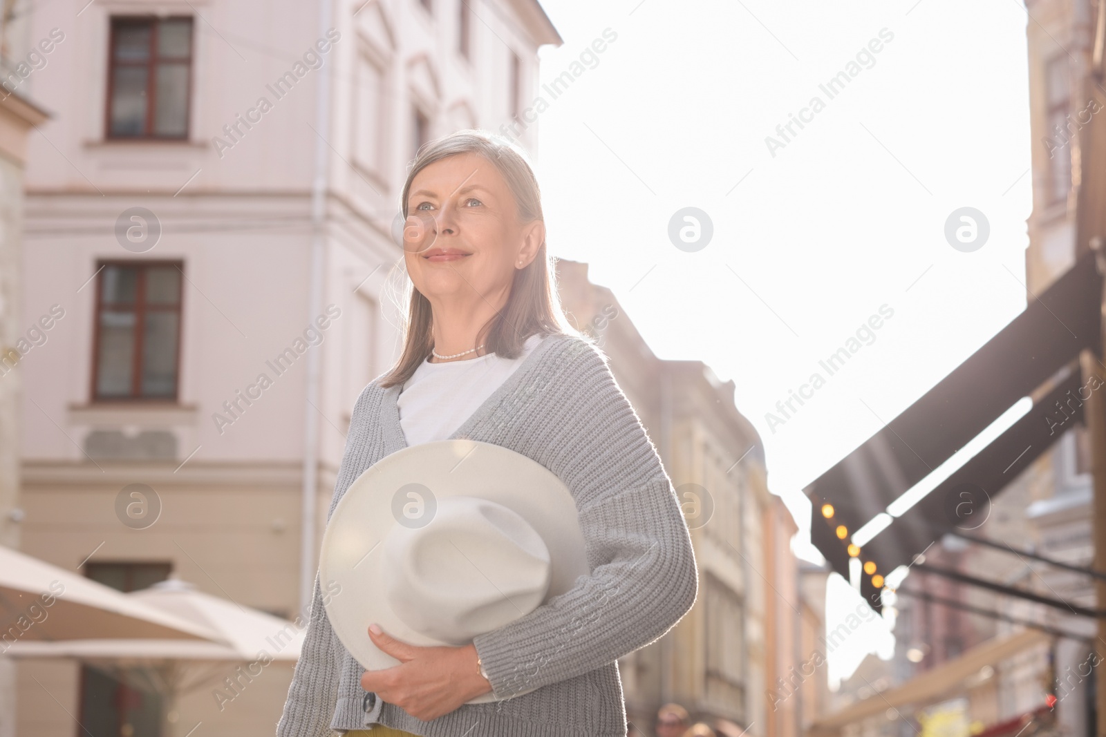 Photo of Beautiful senior woman walking outdoors, space for text