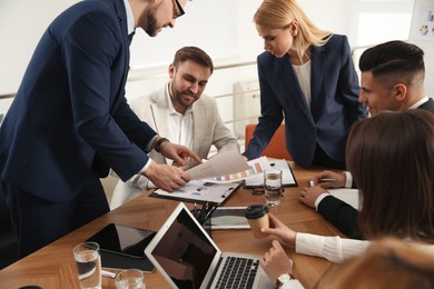 Photo of Businesspeople having meeting in office. Management consulting