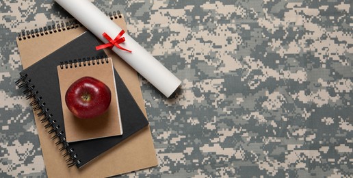 Image of Military education. Notebooks, apple and diploma on camouflage background, flat lay with space for text