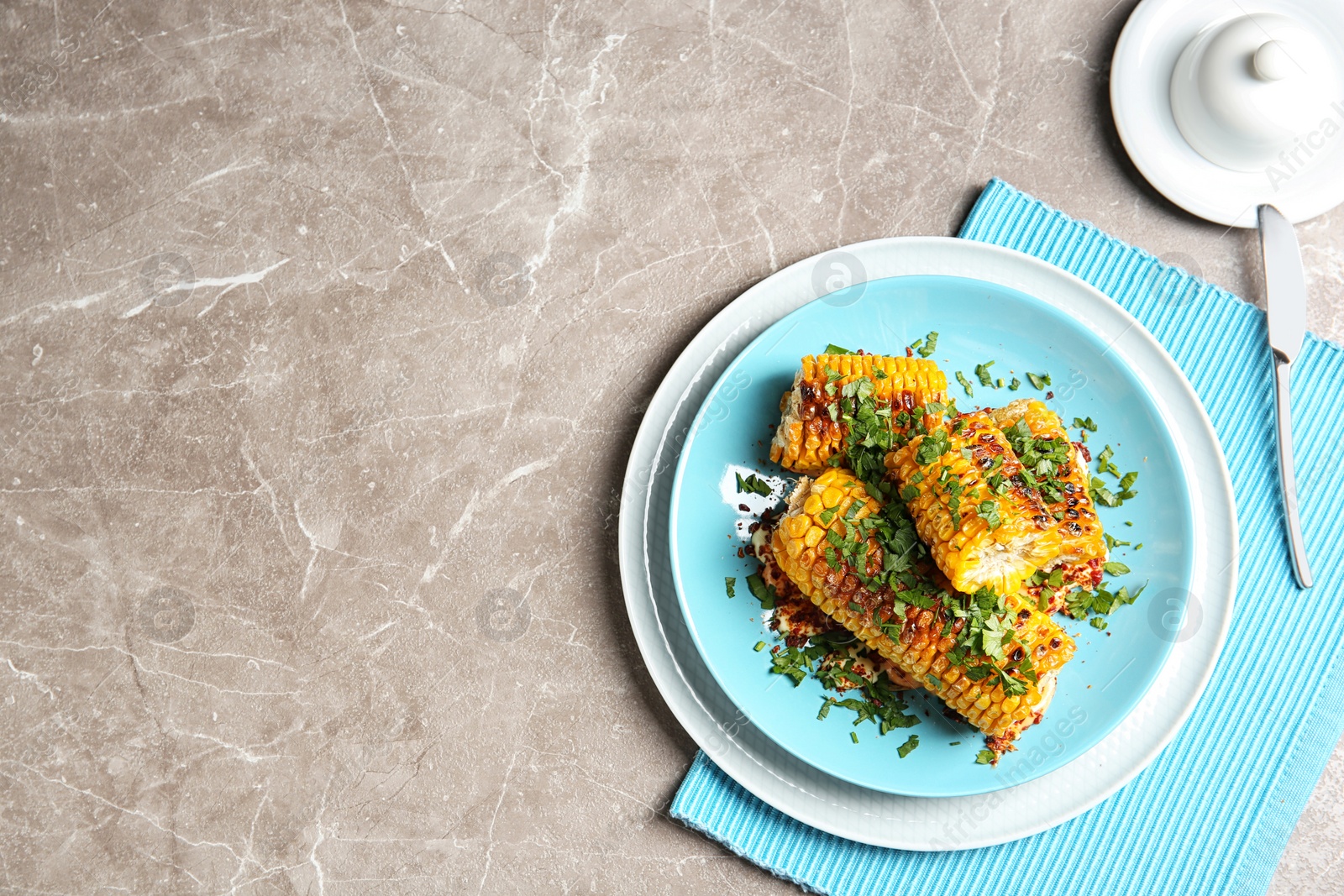 Photo of Plate with delicious grilled corn cobs and parsley on table, top view. Space for text