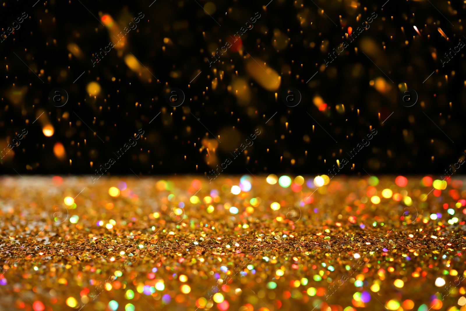 Photo of Many golden paillettes against black background. Space for text