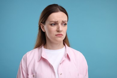 Photo of Portrait of sad woman on light blue background