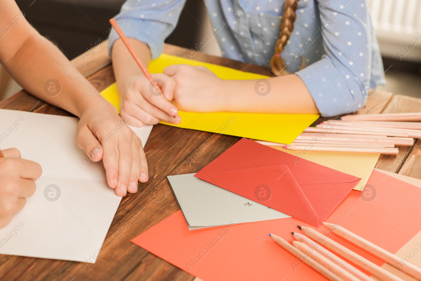 Photo of Children making beautiful greeting cards at table indoors, closeup