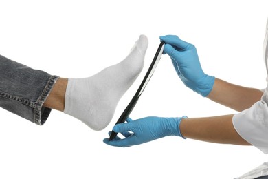 Photo of Orthopedist fitting insole to patient's foot on white background, closeup