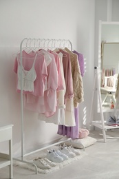 Photo of Dressing room interior with clothing rack and shoes