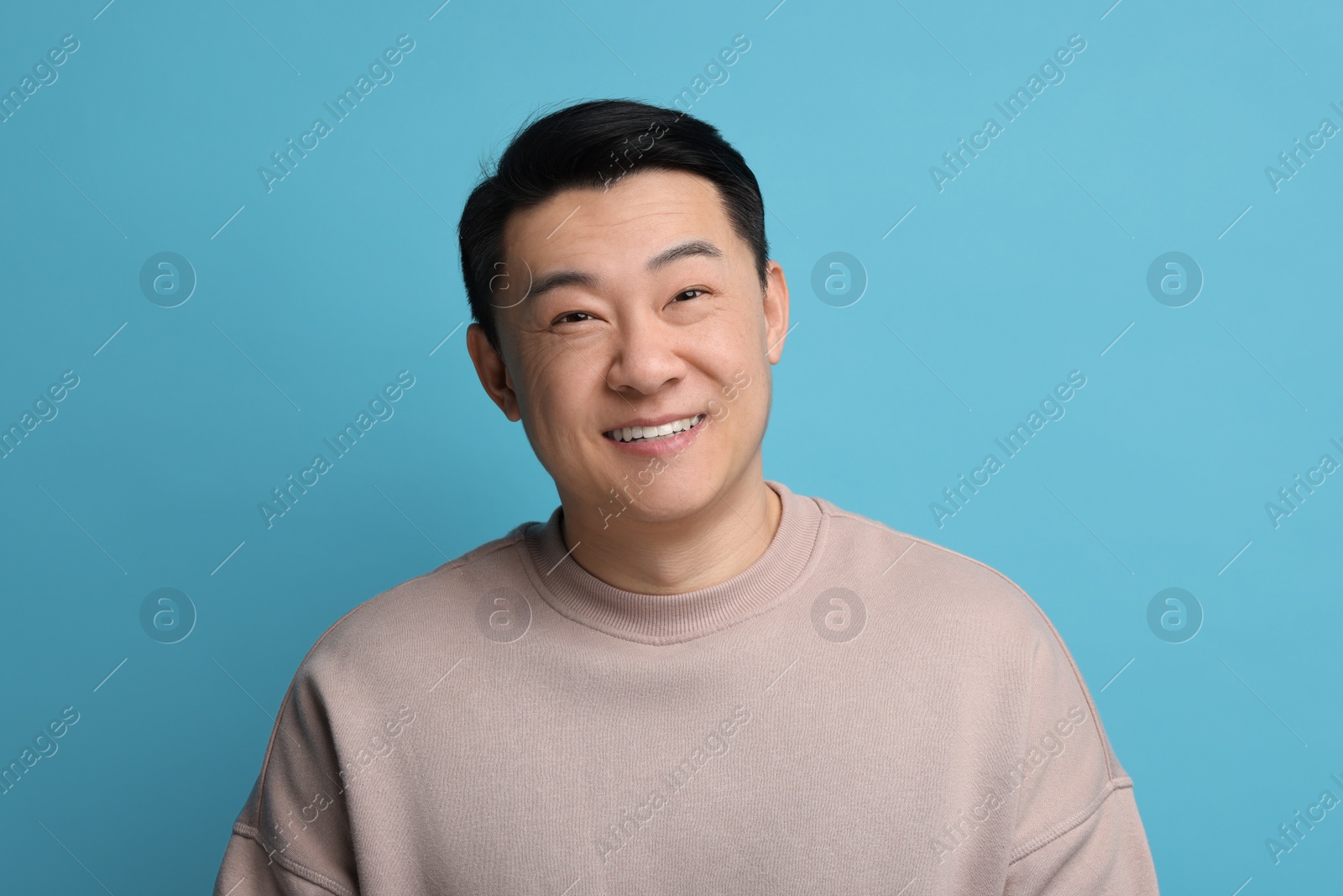 Photo of Portrait of happy man on light blue background