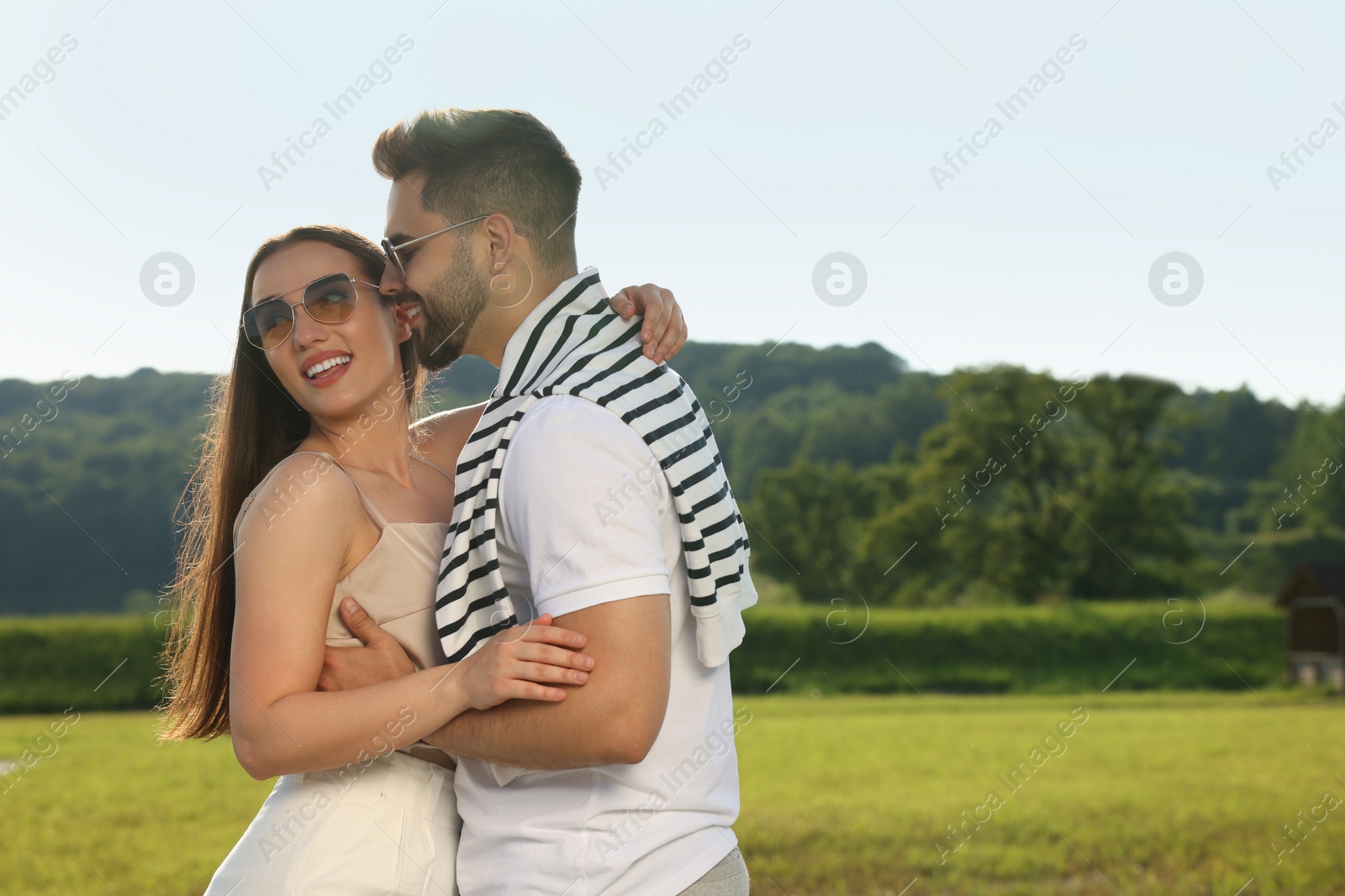 Photo of Romantic date. Beautiful couple spending time together in park, space for text