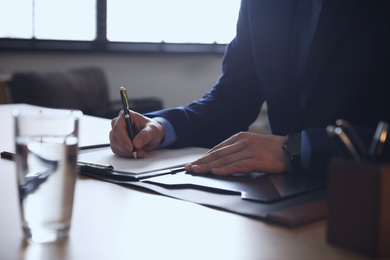 Male lawyer working at table in office, closeup