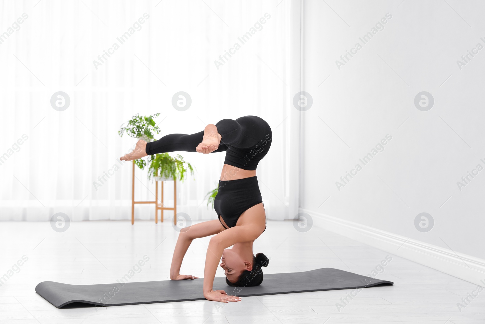 Photo of Professional young acrobat practicing yoga at home