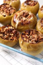 Baked apples in glass dish on table, closeup