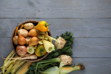 Different fresh ripe vegetables and fruits on grey wooden table, flat lay. Space for text