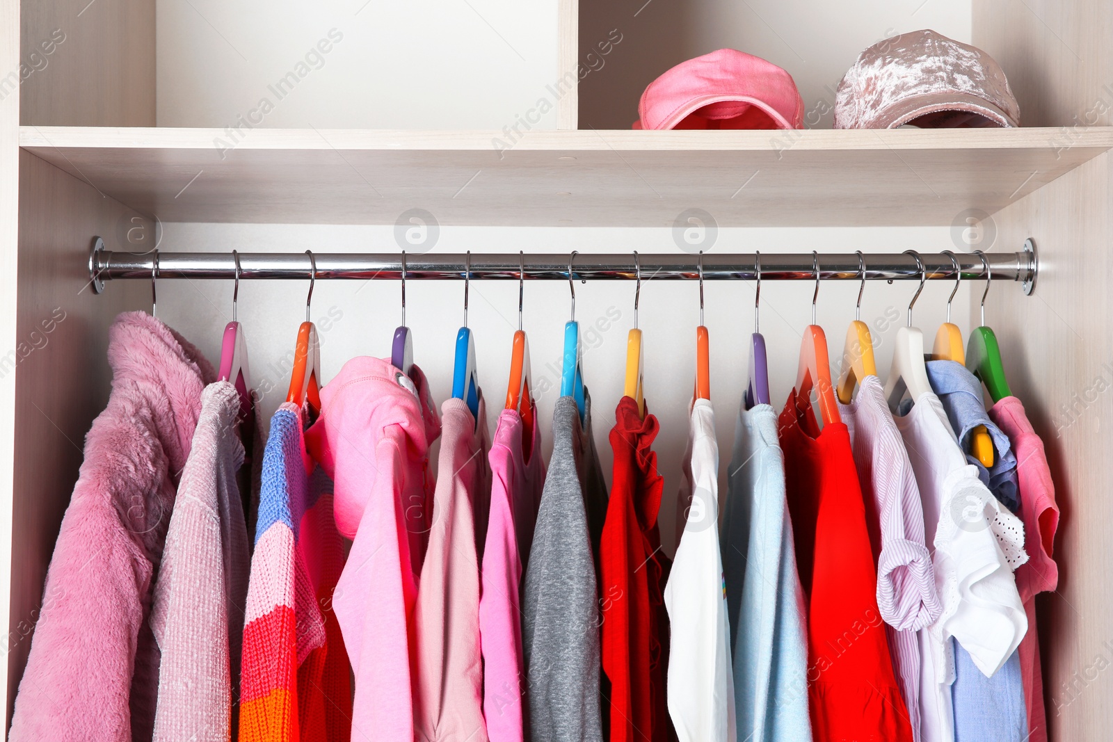 Photo of Wardrobe with stylish girl's clothes hanging on rack