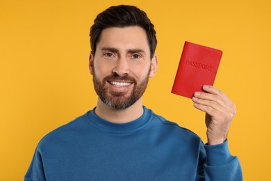 Immigration. Happy man with passport on orange background
