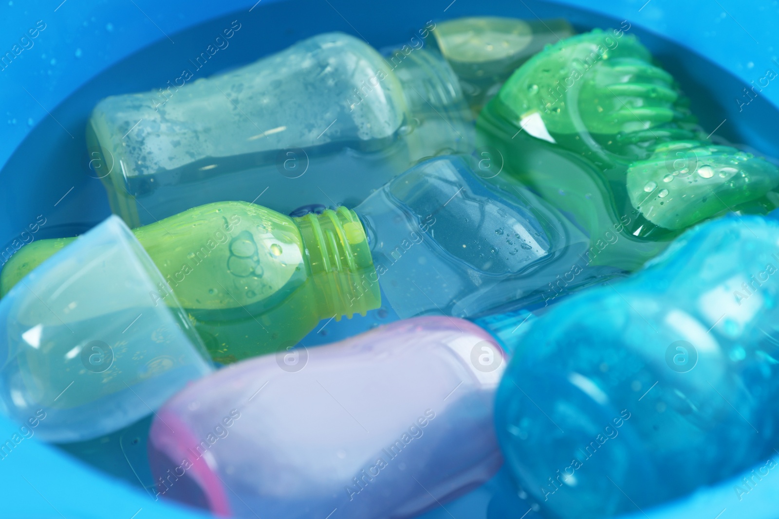 Photo of Light blue basin with baby bottles, closeup