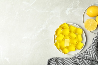 Flat lay composition with plate of lemon jelly on light table. Space for text