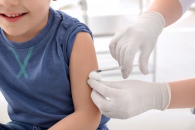 Doctor vaccinating little boy in hospital